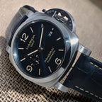 Panerai Luminor GMT PAM01033 angled view showing blue dial, polished steel bezel and blue stitched strap