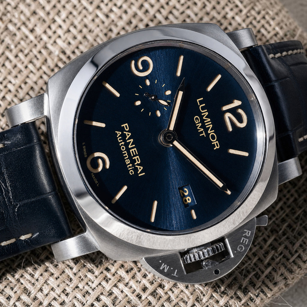 Panerai Luminor GMT PAM01033 blue sandwich dial close-up with date, small seconds and stainless steel crown guard