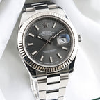 Front view of Rolex Datejust 41 126334 with slate stick dial, fluted bezel and Oyster bracelet on white fabric.
