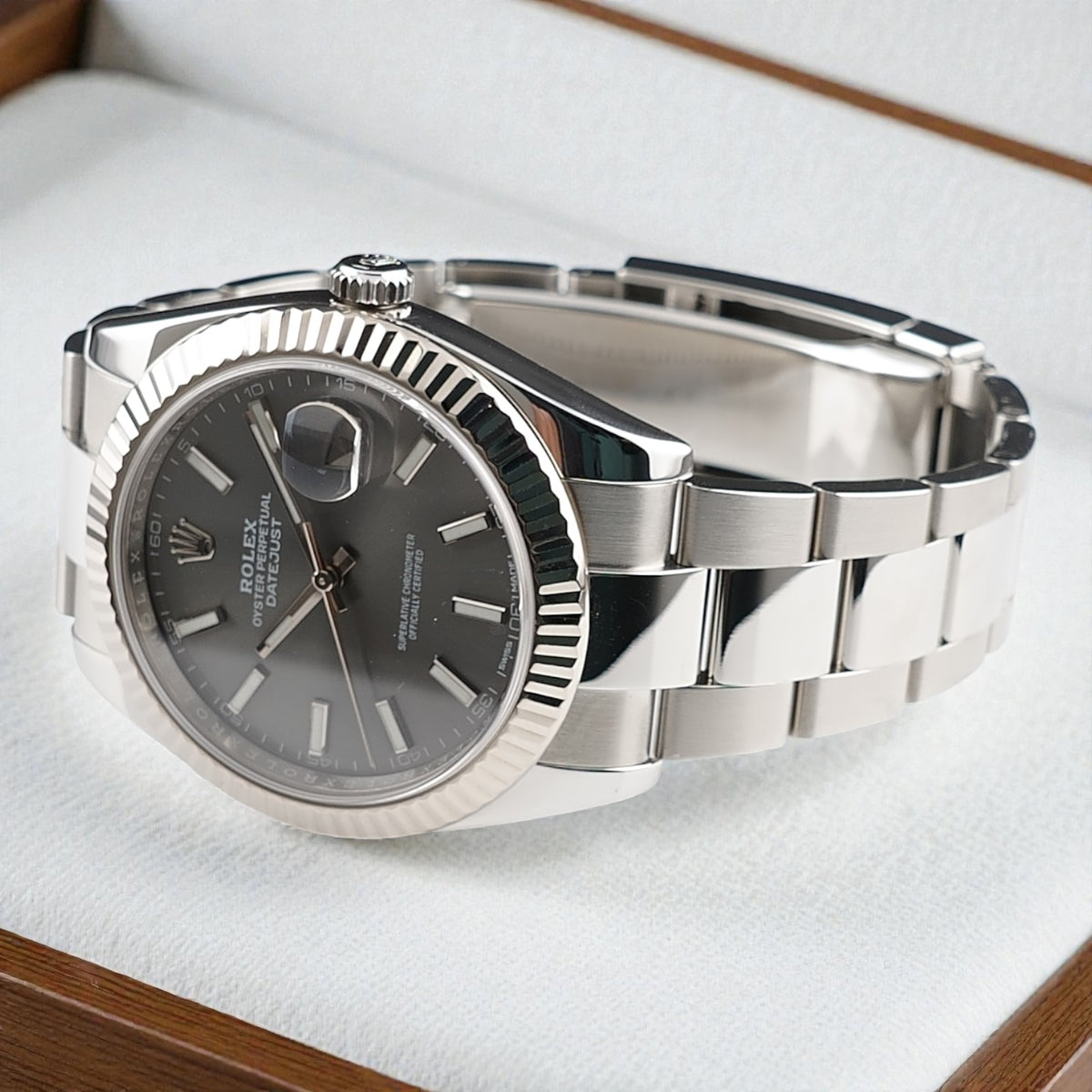 Rolex Datejust 41 126334 resting horizontally on a white cushion with slate dial and Oyster bracelet visible.