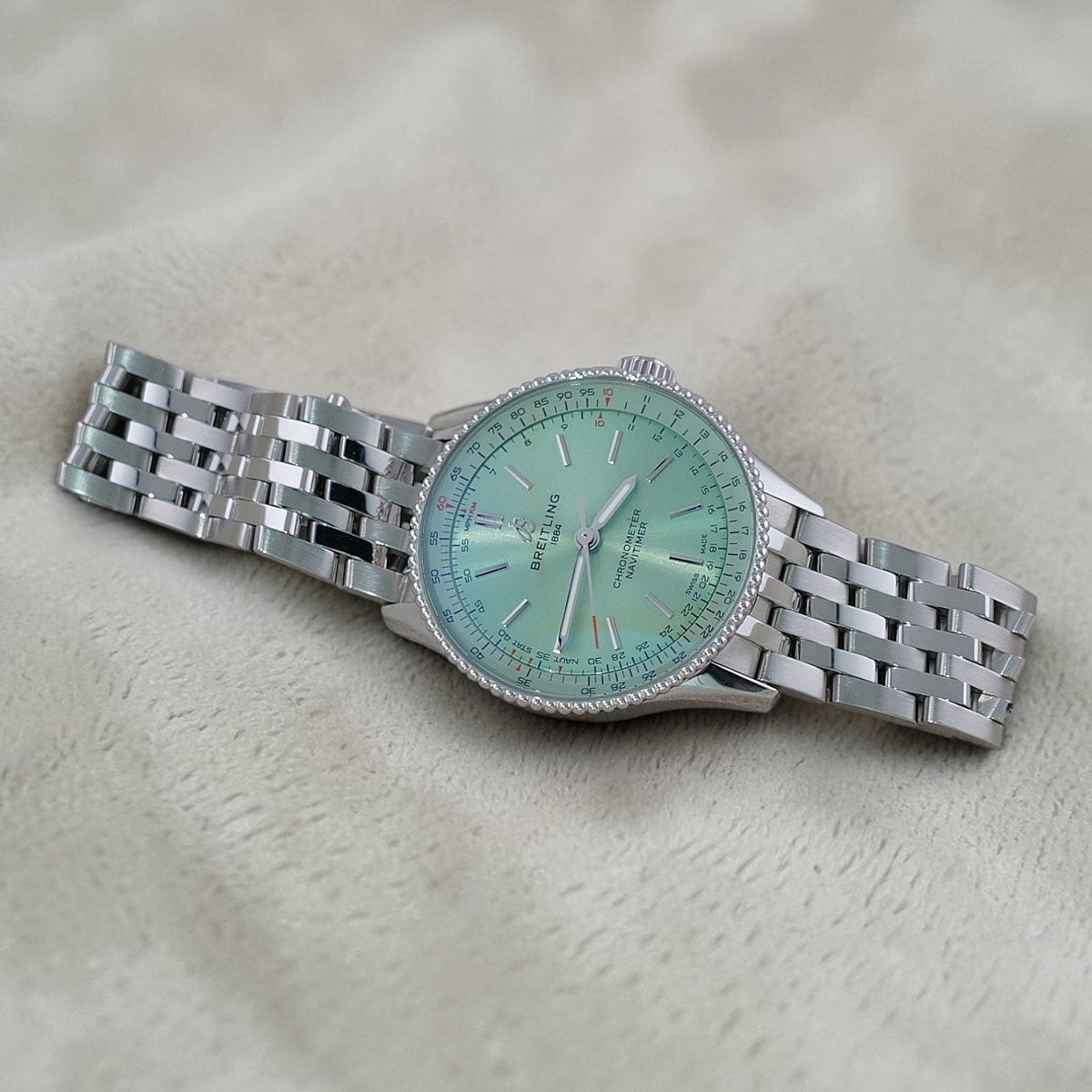 Wrist Flex Timepieces Breitling Navitimer Automatic 36 watch with a mint green dial and stainless steel bracelet.