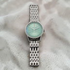 Wrist Flex Timepieces Breitling Navitimer Automatic 36 watch with a mint green dial and stainless steel bracelet.