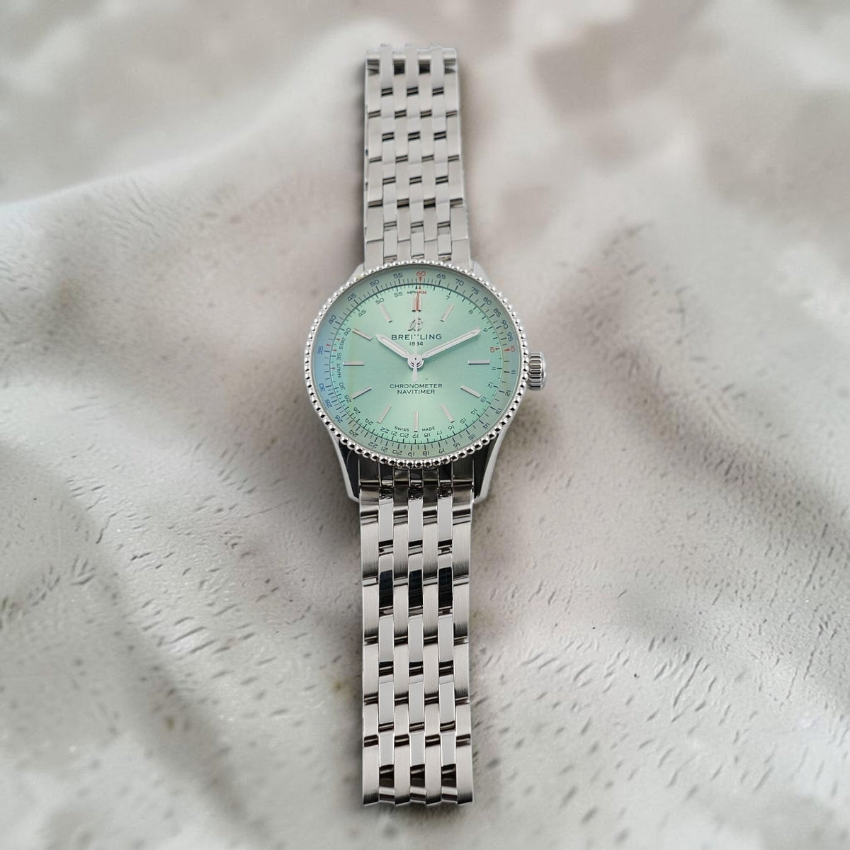 Wrist Flex Timepieces Breitling Navitimer Automatic 36 watch with a mint green dial and stainless steel bracelet.