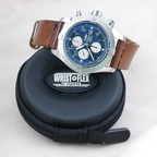 Wrist Flex Timepieces Breitling Super Avenger chronograph with blue dial and brown leather strap on a travel case
