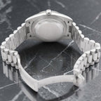 Wrist Flex Timepieces Rolex Day-Date watch showing the back of the silver President bracelet and case on marble
