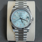 Wrist Flex Timepieces Rolex Day-Date watch with an ice-blue dial, baguette diamond markers, and a fluted bezel.